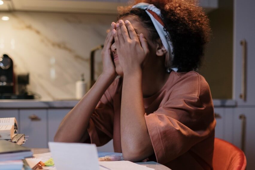 woman working from home, frusrated with head in hands