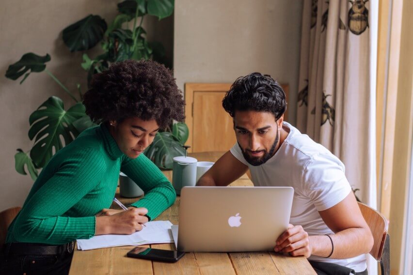 Two people looking at laptop at a table