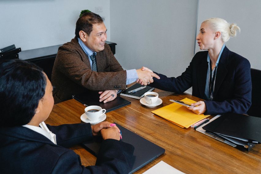 Accountants working in a boardroom and shaking hands